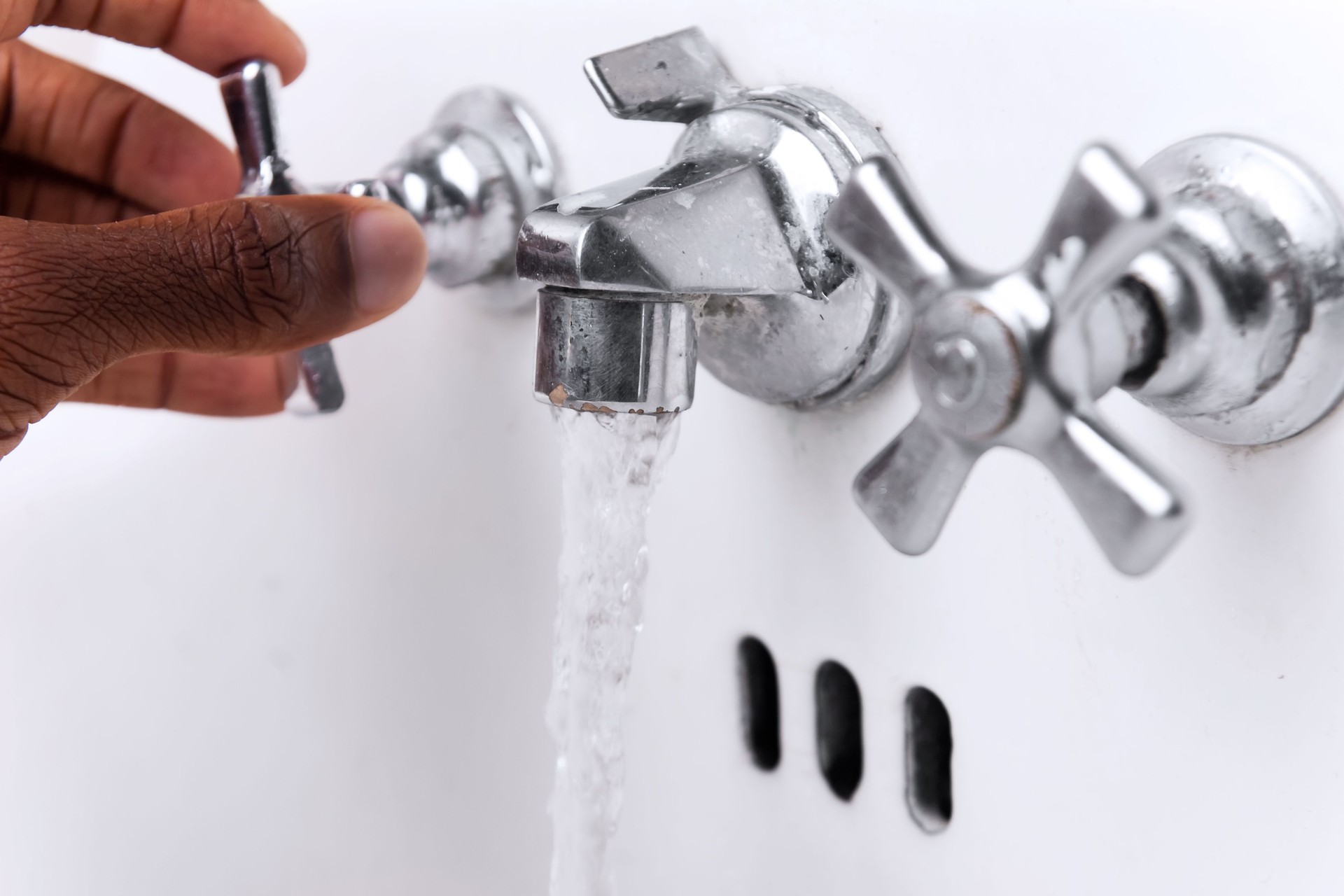 Hand on faucet with running water Weekly Water Flushing For Legionella Prevention (ACOP L8 Compliance)